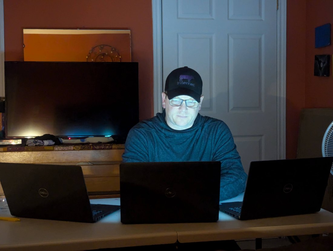 Dan working late on three laptops